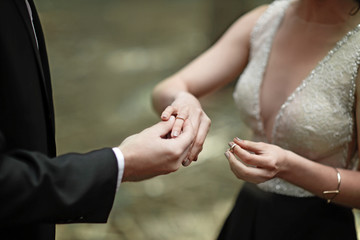 Shot moment when the groom puts the ring on a young bride's hand