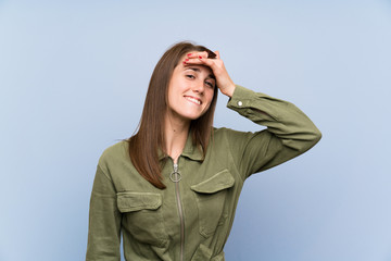 Young woman over isolated blue wall laughing