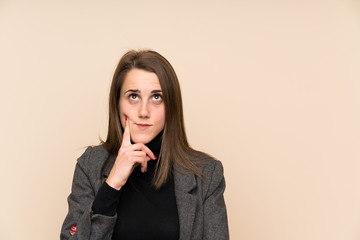 Young woman over isolated wall thinking an idea