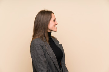 Young woman over isolated wall standing and looking to the side