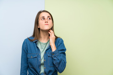 Young woman over colorful background standing and thinking an idea