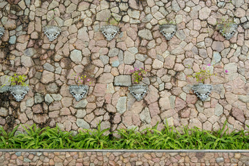 Decoration stone wall with pink flower in roman pot.