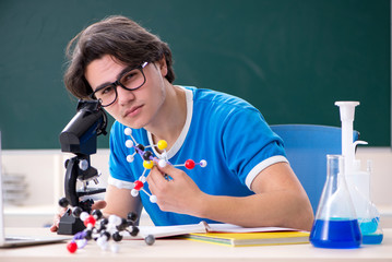 Young male student in the classroom 