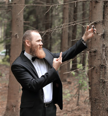 successful businessman taking a selfie in a pine forest