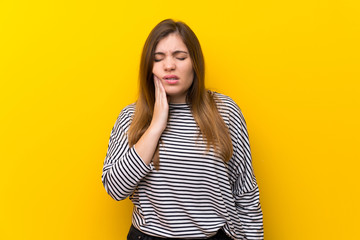 Young girl over yellow wall with toothache