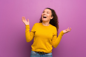 Teenager girl over purple wall smiling a lot