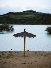 Lonely umbrella in desert shore