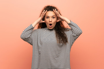 Teenager girl over pink wall with surprise expression