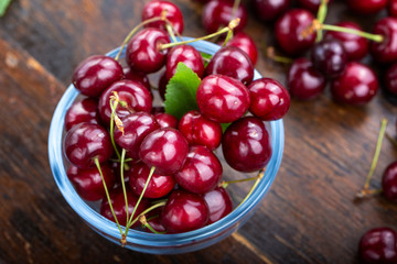 cherry in glass plate with wooden background.