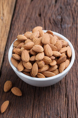 Almond nut in a ceramic bowl against wooden table