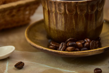 A closeup shot of a coffee cup and coffee beans.