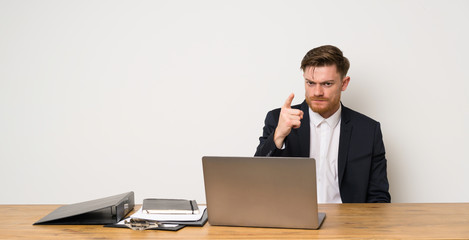 Businessman in a office frustrated and pointing to the front