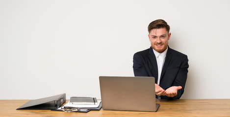 Businessman in a office holding copyspace imaginary on the palm to insert an ad