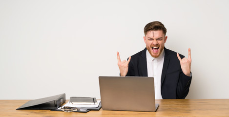 Businessman in a office making rock gesture