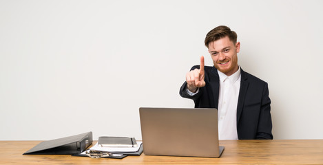 Businessman in a office showing and lifting a finger