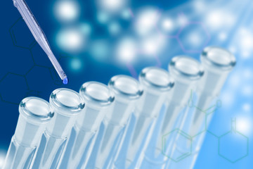 Pipette dropping a sample into a test tube, closeup