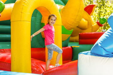 Fototapeta na wymiar Joyful little girl playing on a trampoline