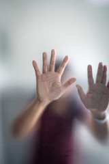 Blurry woman hand behind frosted glass metaphor panic and negative dark emotional