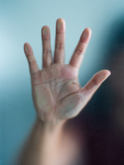 Blurry woman hand behind frosted glass metaphor panic and negative dark emotional