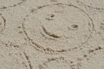 Fototapeta na wymiar smiling sun on sand drawing