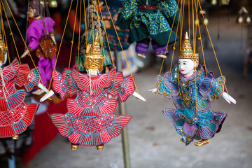 Traditional laotian souvenir wooden marionnette puppets at one of markets of Luang Prabang