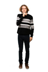 Full-length shot of Blonde man showing a sign of silence gesture putting finger in mouth over isolated white background