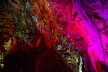 pink illuminated formations in Prometheus Cave