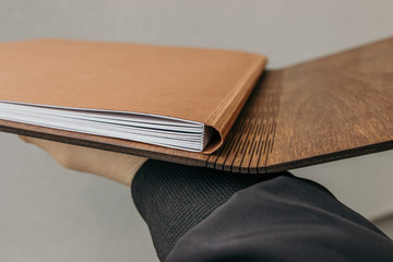 Open photo book with wooden cover. notebook with plywood cover. Wedding photo book with wooden cover. Wedding album in hands.