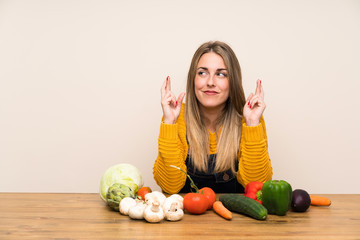 Fototapeta premium Woman with lots of vegetables with fingers crossing