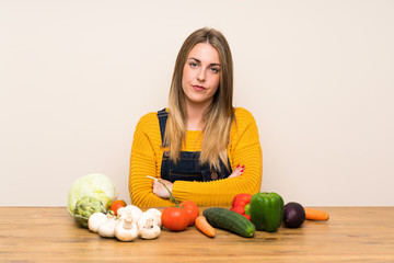 Fototapeta premium Woman with lots of vegetables keeping arms crossed