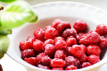 Close-up red frozen berries in white plate, summer fruit, photo