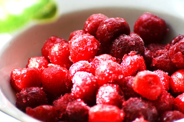 Close-up red frozen berries in white plate, summer fruit, photo