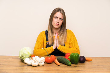 Fototapeta premium Woman with lots of vegetables pleading