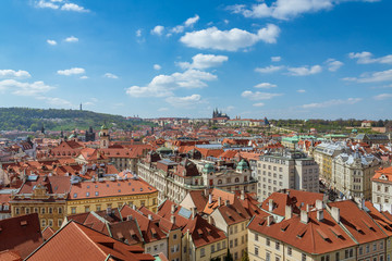 Obraz premium Outdoor sunny panoramic aerial scenery of rooftop in old town, city skyline, Charles Bridge tower and background range of mountain with Prague Castle and St. Vitus Cathedral in Prague, Czech Republic.