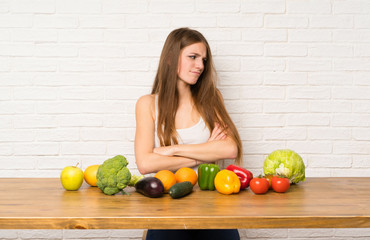 Fototapeta premium Young woman with many vegetables standing and thinking an idea