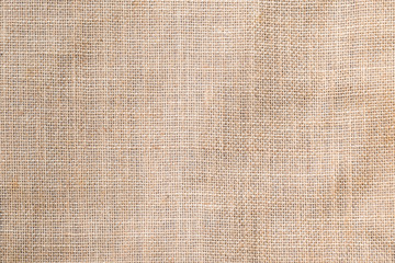 Hessian sackcloth woven texture pattern background in light sepia tan beige cream brown color