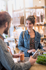 In a grocery store, a young woman at the cash register 