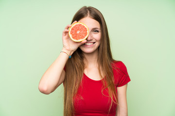 Young woman with long hair holding a grapefruit