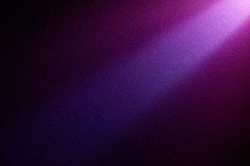 A bright beam of light shines from top to bottom on a darker background.