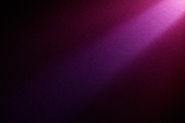 A bright beam of light shines from top to bottom on a darker background.