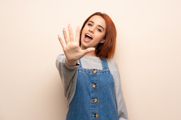 Young redhead woman over isolated background counting five with fingers