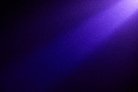 A bright beam of light shines from top to bottom on a darker background.