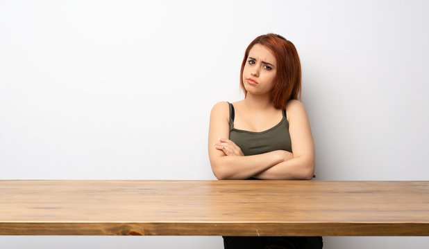 Young redhead woman at desk feeling upset