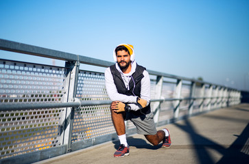 Fitness man stretching at bridge