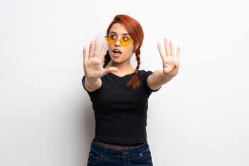 Young redhead woman over white wall counting nine with fingers