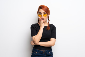 Young redhead woman over white wall surprised and shocked while looking right
