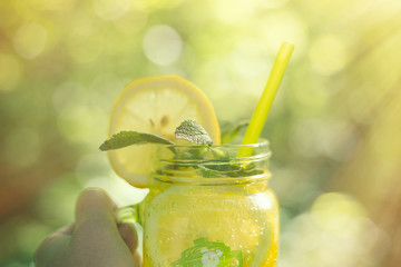 Lemonade or Mojito cocktail with lemon and mint, cold refreshing drink in the sun