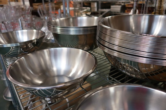 several stacks of empty stainless steel restaurant service bowls 