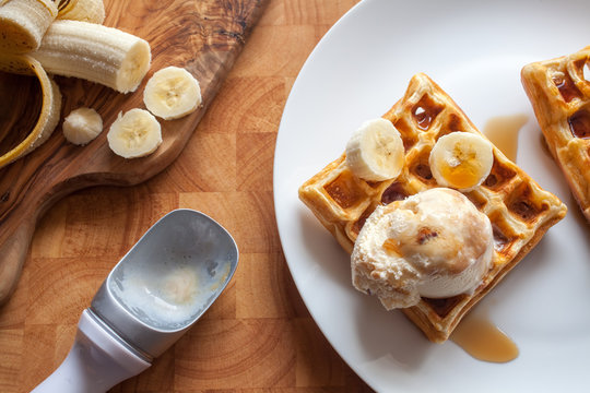 Banana waffles dessert with ice cream and maple syrup close-up