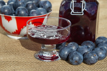 Plum jam and fresh plums on burlap